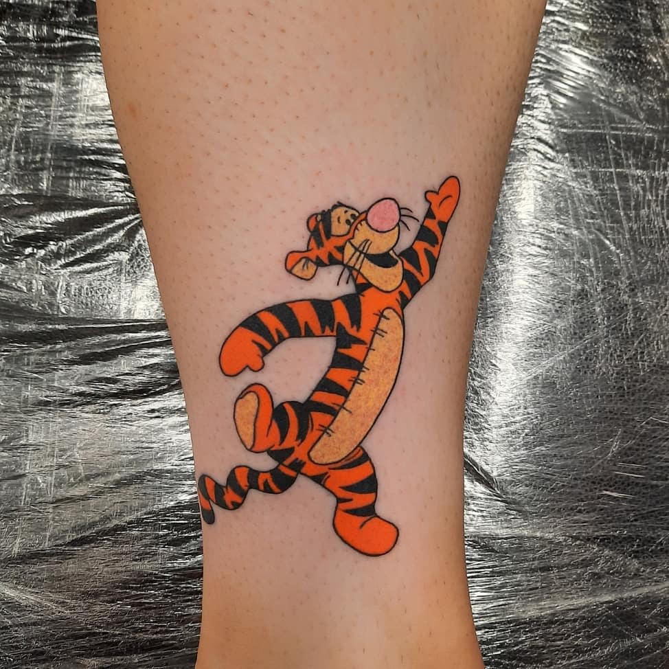 Tattoo of Tigger, from Winnie the Pooh, joyfully jumping on a calf